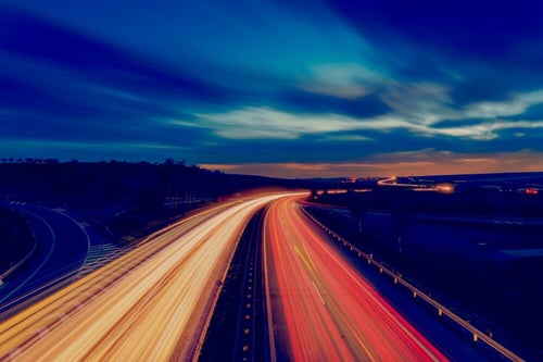 Image of a busy highway with streaking lights